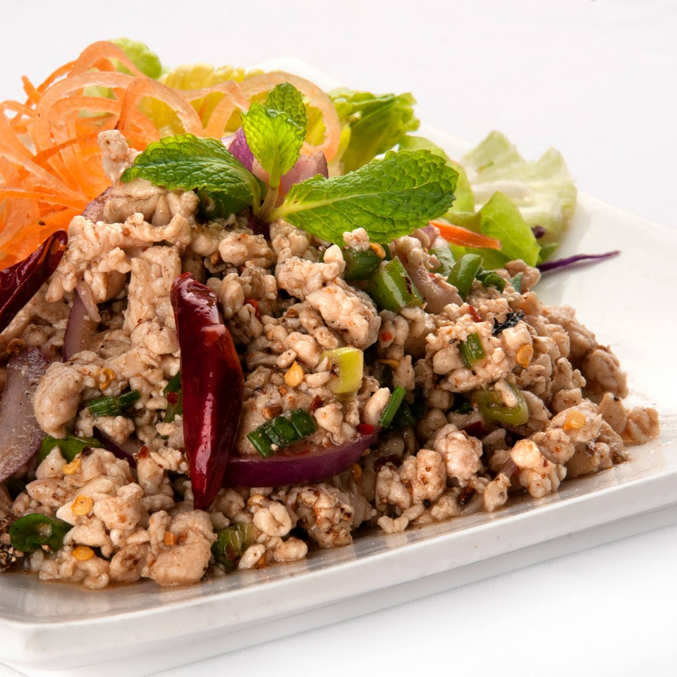 Thai Larb Gai, a minced chicken salad with mint, red onion, and chili, on a white plate.